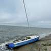 A sailboat the U.S. Coast Guard said washed ashore on Russian Beach in Stratford, Conn. Authorities are trying to track down the owner of the vessel, but said the boat does not have a hull number.