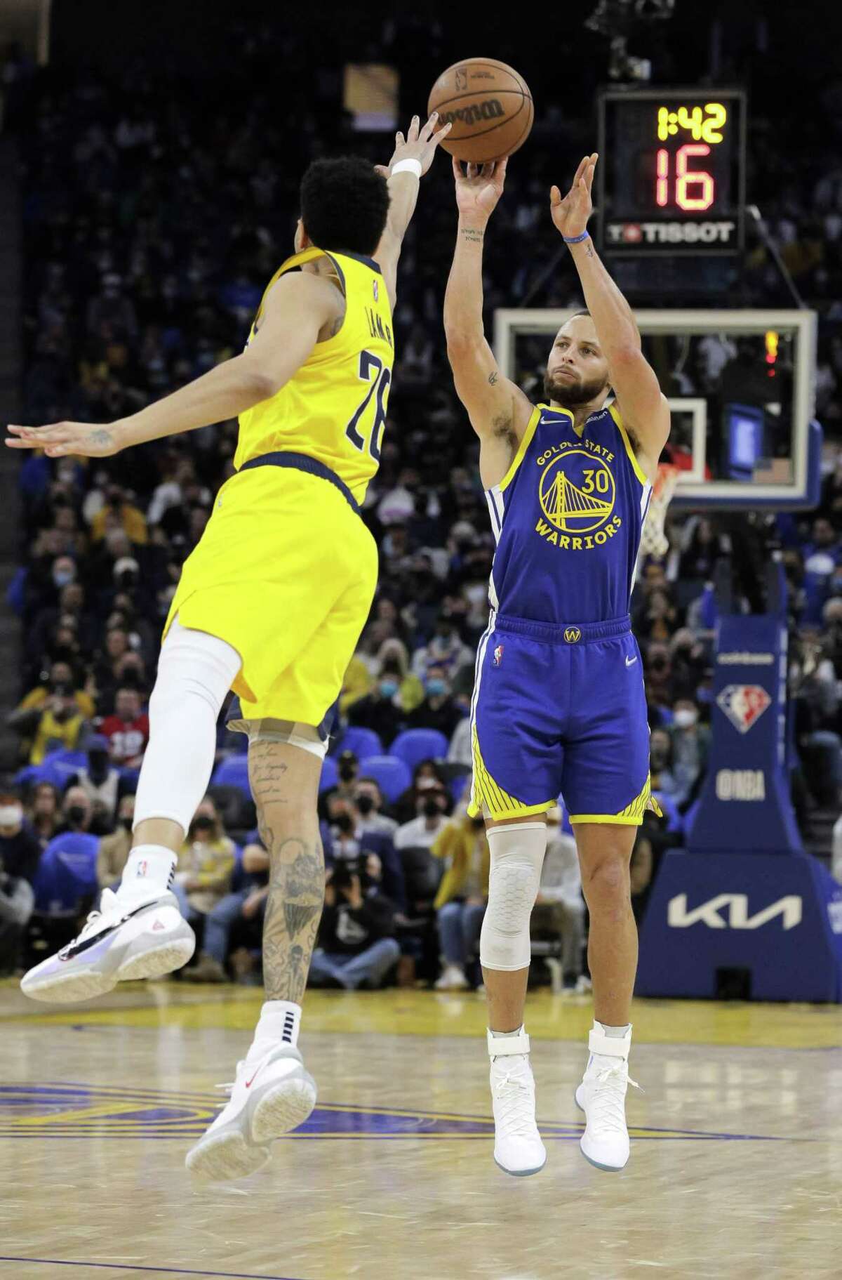 Stephen Curry (30)shoots a three pointer over Jeremy Lamb (26) in the first half as the Golden State Warriors played the Indiana Pacers at Chase Center in San Francisco, Calif., on Thursday, January 20, 2022.