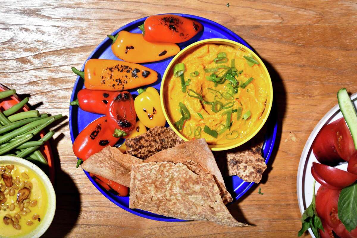 Blistered sweet peppers and toasted lavash pair perfectly with a dip of cashews and carrots (center).