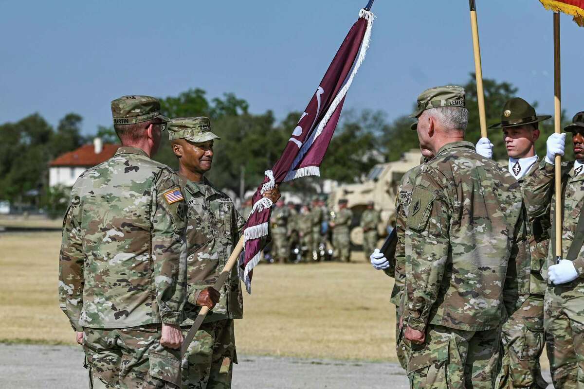 Maj. Gen. Michael J. Talley, middle, holds the guidon signifying his new command at the U.S. Army Medical Center of Excellence during a change of command ceremony at Ft. Sam Houston on Thursday, June 23, 2022. Maj. Gen. Dennis LeMaster, at right, relinquished command to Maj. Gen. Talley. Lt. Gen. Theodore Martin, at left, presided over the event. More than 5,000 soldiers are assigned to MEDCoE, which trains about 35,000 medical specialists a year, including all the Army’s combat medics.
