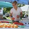 Felice Martin of Nature View Farm in Bridgewater previously prepares a produce selection at the Fairfield Farmers Market in a recent year. The market has returned, began for its seventh season, and 2022 June 12, with the event being every Sunday, from 10 a.m. to 2 p.m. rain or shine on the Sherman Green in Fairfield, and over 30 local farms, and small batch food producers participating in the grocery shopping option.