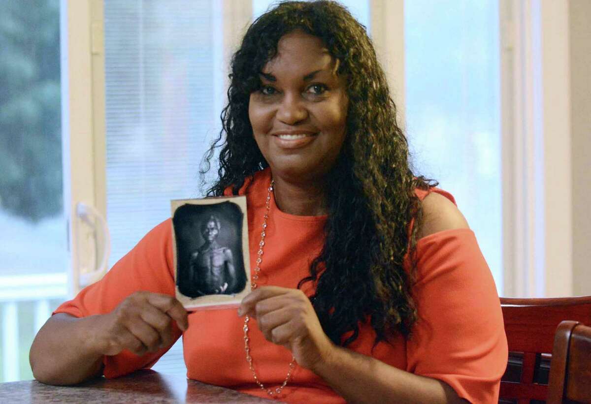 Tamara Lanier holds an 1850 photograph of a South Carolina slave named Renty, who Lanier said is her family's patriarch, on July 17, 2018, at her home in Norwich, Conn. Lanier, who says she's descended from slaves portrayed in widely-published, historical photos owned by Harvard, can sue the Ivy League university for emotional distress, Massachusetts' highest court ruled Thursday June 23, 2022.