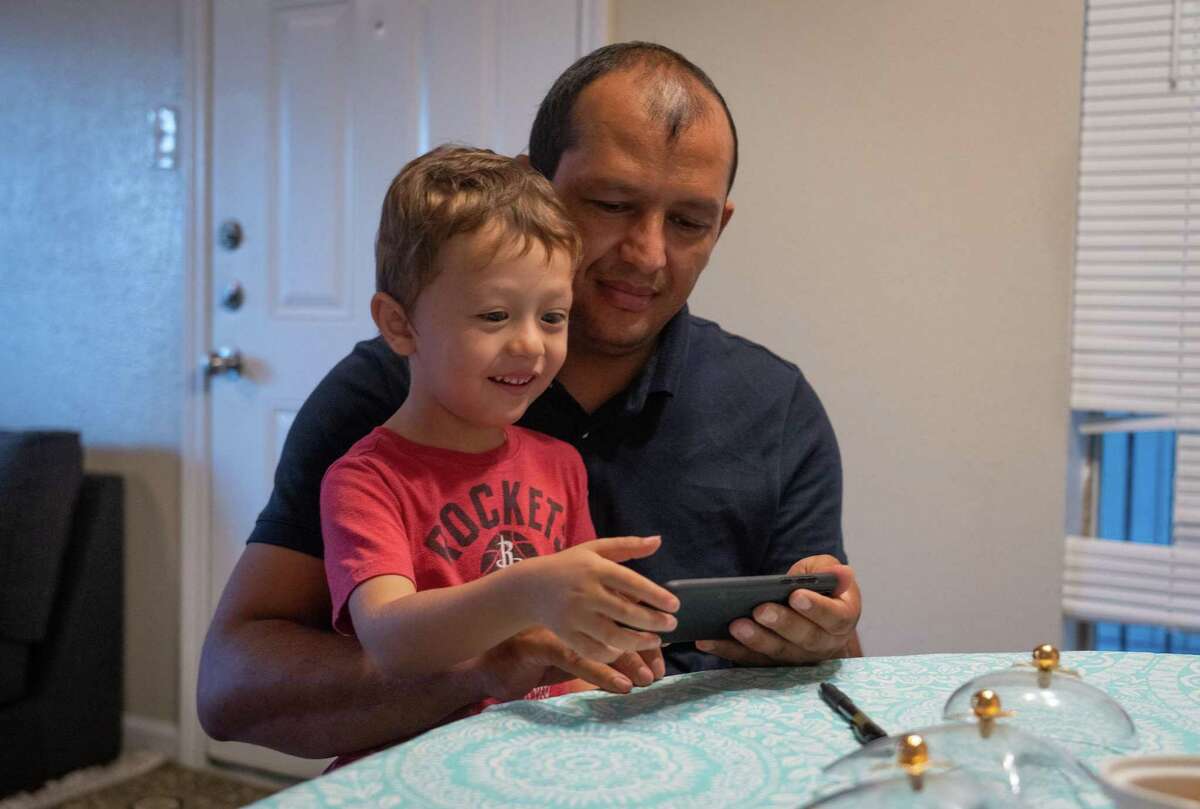 Delagha Askerzada, who worked with the U.S. military for years as an interpreter, plays a game with his 4-year-old son Sayed Abas in the family’s apartment, Tuesday, June 21, 2022, in Houston.