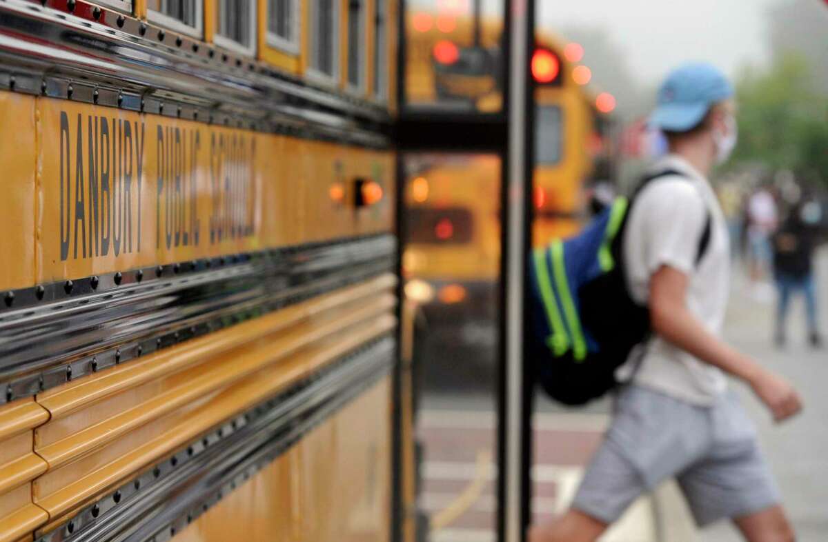 Students get of the buses at Danbury High School on the first day of the new school year. Monday, August 30, 2021, in Danbury, Conn.