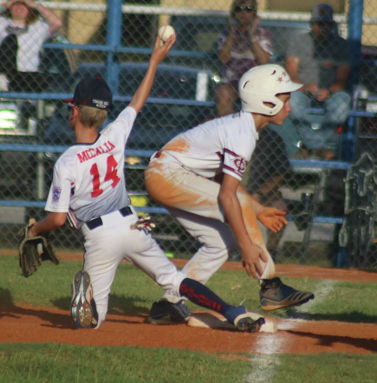 Jacob McGee, the hottest Little League batter in Texas at the moment, stands up after sliding into third with a first-inning triple Thursday night. Bayside third baseman Jack McCalla, who played well offensively and defensively, throws the ball back to the pitcher.