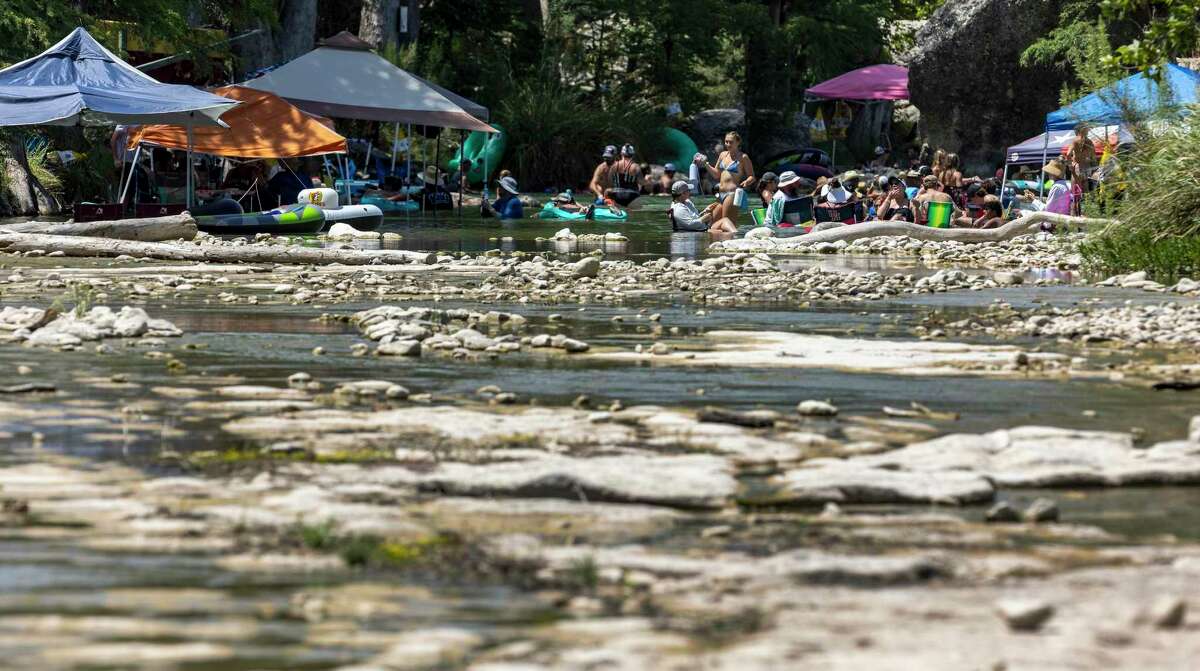 People gather on June 23 in the nearly dry Frio River in Concan. The U.S. Geological Survey’s river gauge in Concan measured zero flow in the river that day.