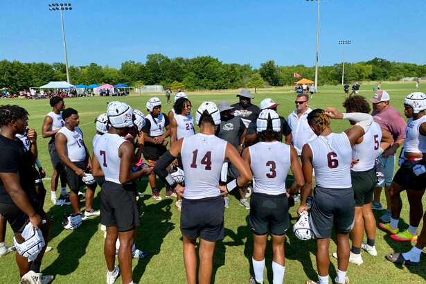 The Silsbee 7-on-7 football team huddles after a game on Friday in College Station. 