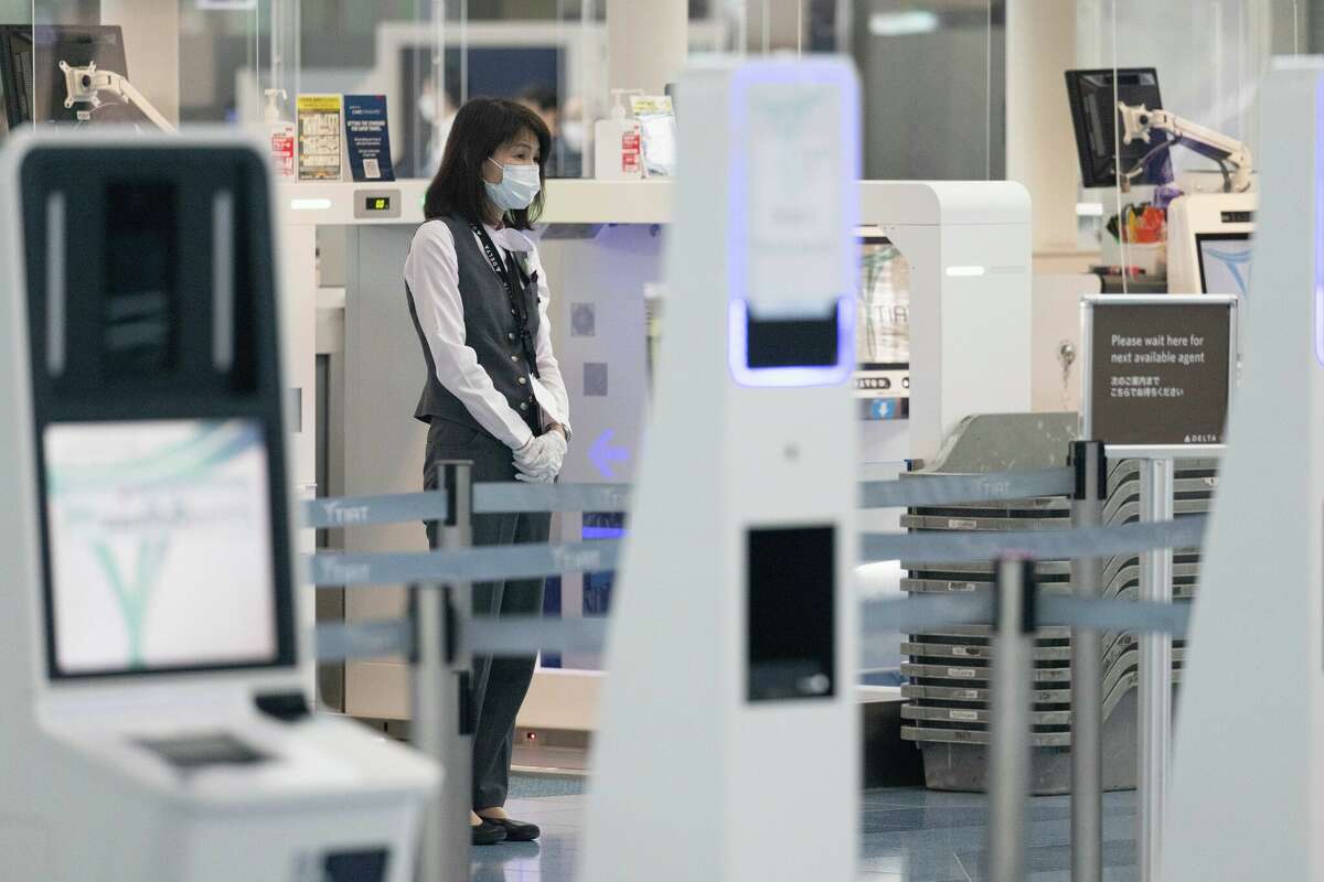 A sole Delta Airlines employee waiting at the check-in counter inside International Terminal at Haneda Airport.