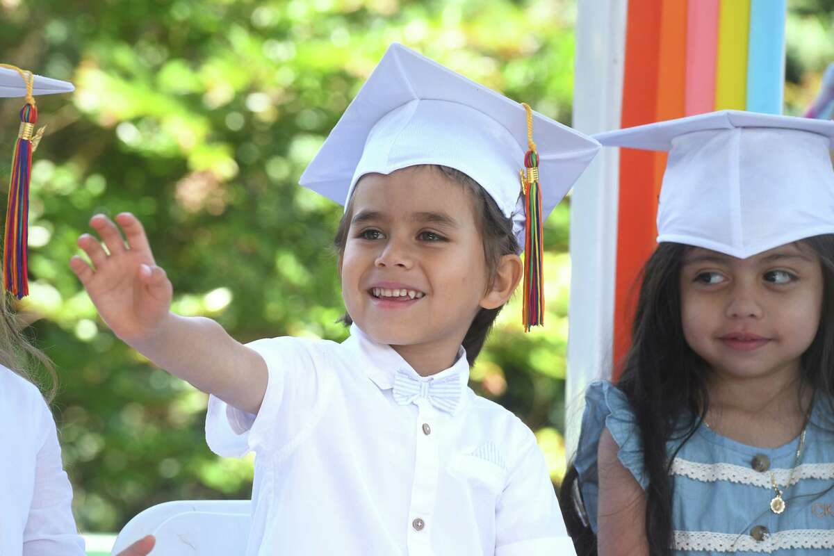Lucas Ruvolo waves to his family during a graduation ceremony for Armstrong Court Preschool students held at Byram Park, in Greenwich, Conn. June 24, 2022.