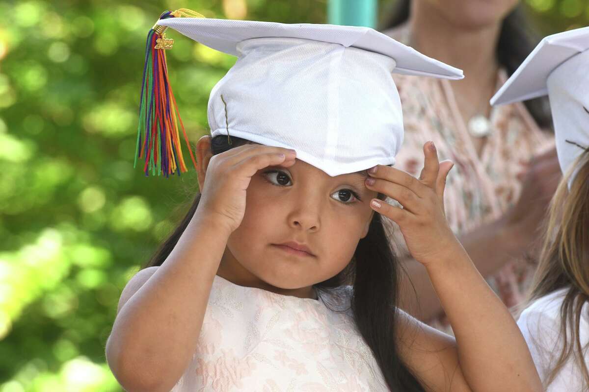Valentina Beltran adjusts her cap during a graduation ceremony for Armstrong Court Preschool students at Byram Park, in Greenwich, Conn. June 24, 2022.