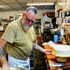 Dan Raymond, owner of Zachary's Patsry Shoppe, frosts one of the dozens of cakes he's making for events this weekend. 