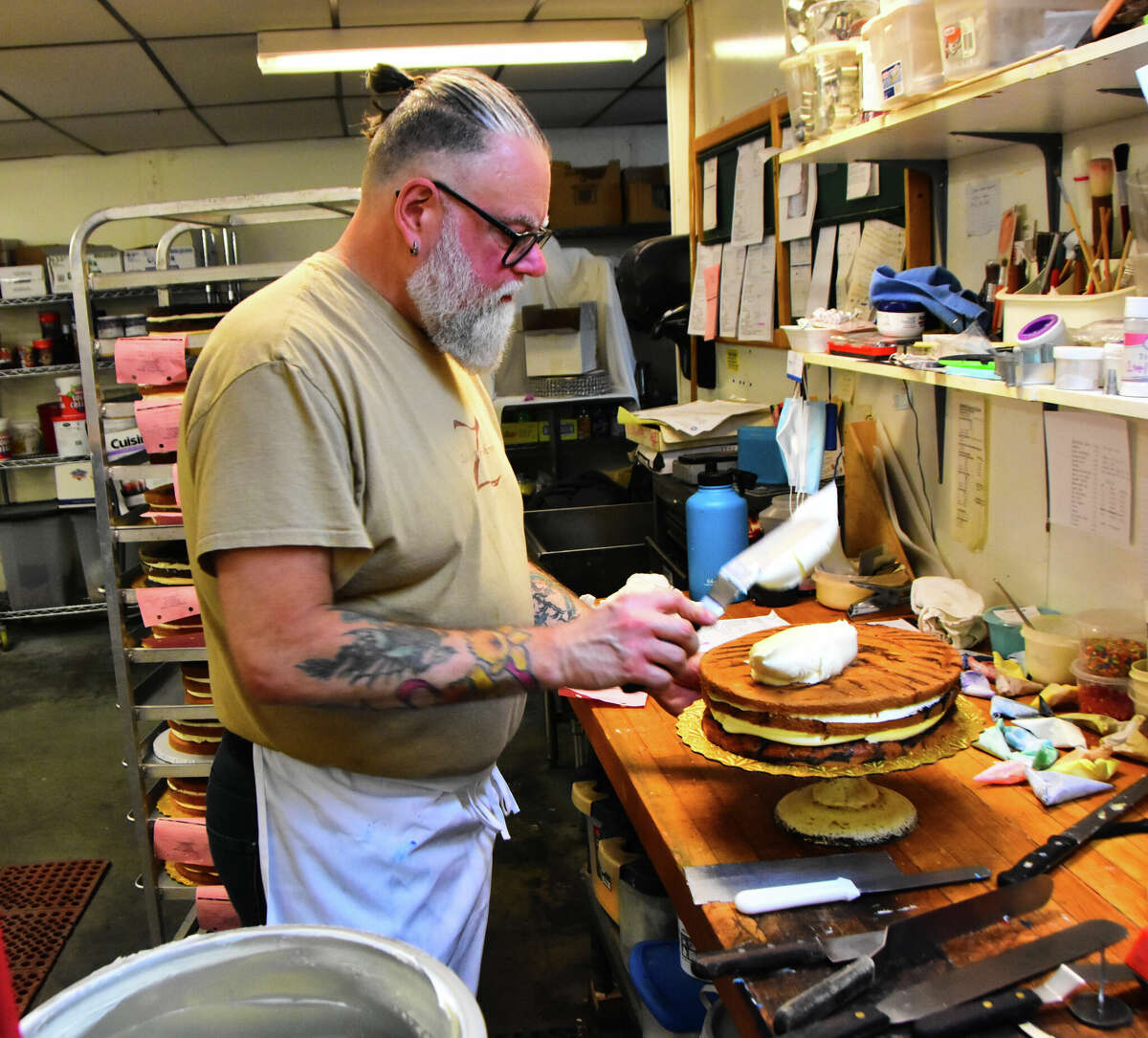 Dan Raymond, owner of Zachary's Patsry Shoppe, frosts one of the dozens of cakes he's making for events this weekend.&nbsp;
