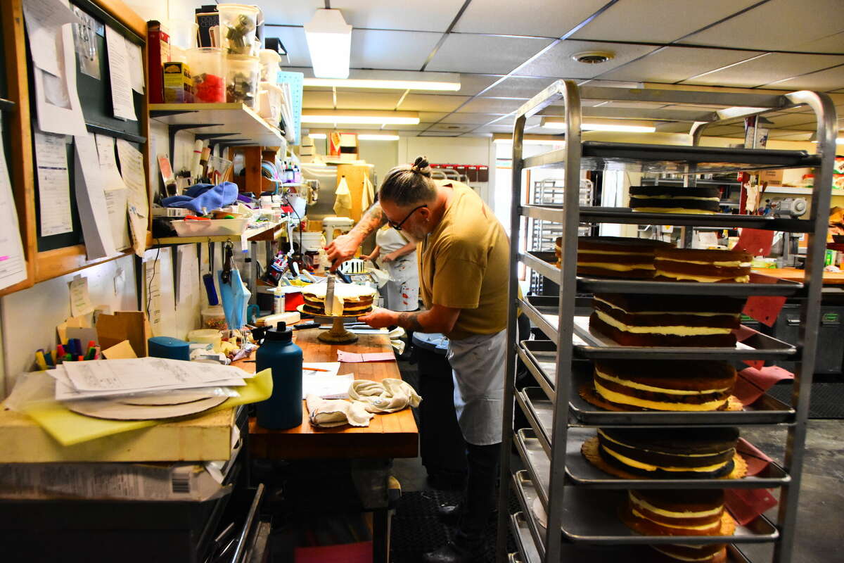 Dan Raymond, owner of Zachary's Patsry Shoppe, frosts one of the dozens of cakes he's making for events this weekend.&nbsp;