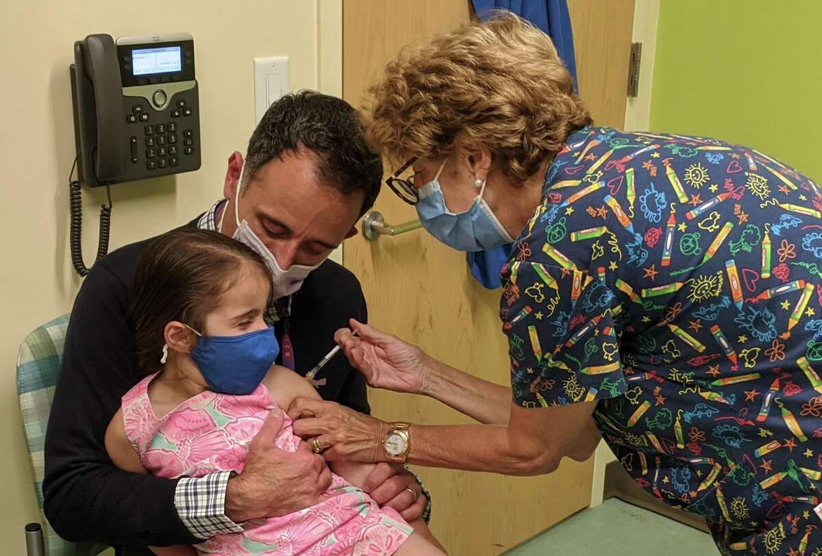 Gracie Porto, three and a half-years-old, was among the first kids to receive the Moderna vaccine against COVID-19 as part of Greenwich Hospital’s clinic. Porto was held close by her father Anthony as she got the shot from nurse Andrea Daur.