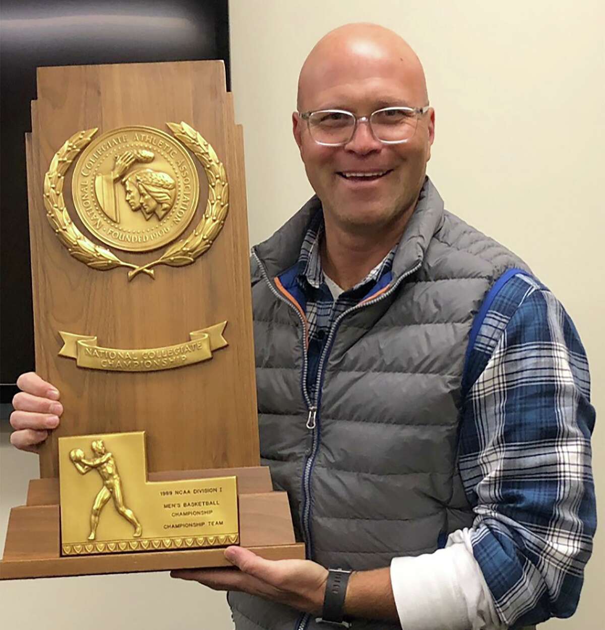 Westport’s Dave Goldshore, shown holding Michigan’s 1989 NCAA Tournament men’s basketball trophy, has been named the new head coach for Staples boys basketball after five years as an assistant for former coach Colin Devine. Goldshore is a Michigan alum.