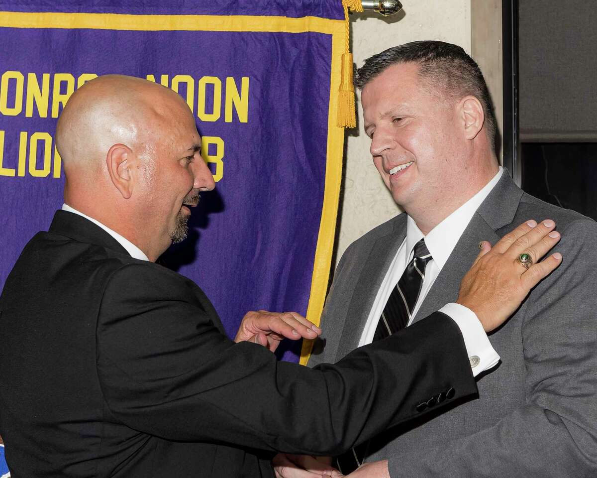 Changing of the Guard - The Conroe Noon Lions Club outgoing club President Steve Williams (l) pins the club’s incoming President Warner Phelps (r) at their Installation Banquet with the club’s traveling President lapel pin rumored to be over 80 years old.