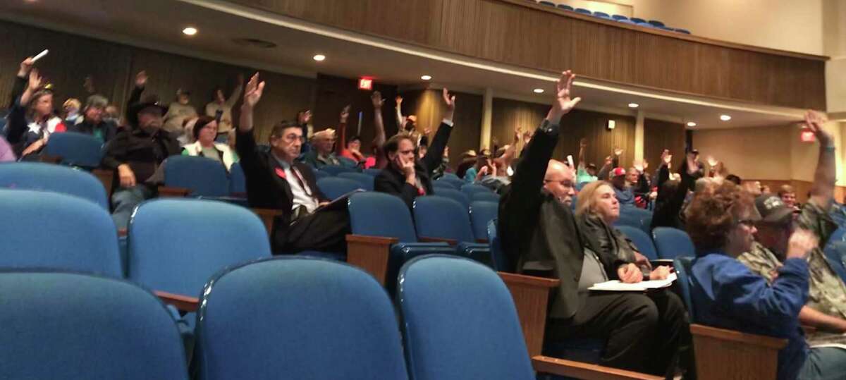 Central Texas residents raise their hands at a public hearing Jan. 31, 2018, in Fairfield to show opposition to a plan by Texas Central Partners to develop a 240-mile high-speed rail line between Houston and Dallas.