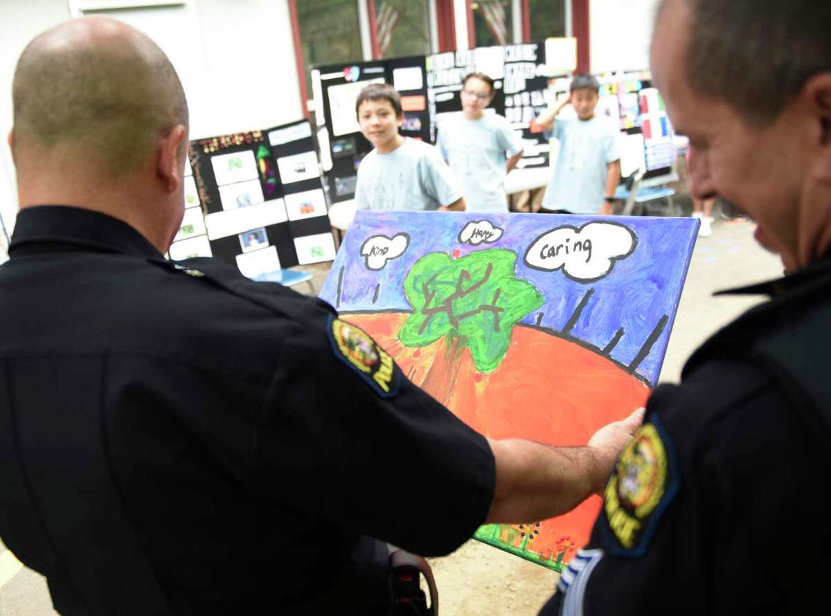 Greenwich police officers view a painting by fifth-grader Isaac Farr about his research project Artistic Expression at Dundee International School in the Riverside area of ​​Greenwich, Connecticut, Tuesday, June 21, 2022. Farr's research project focused on art and gratitude. created a picture of the Greenwich Police Department to express his gratitude through art.