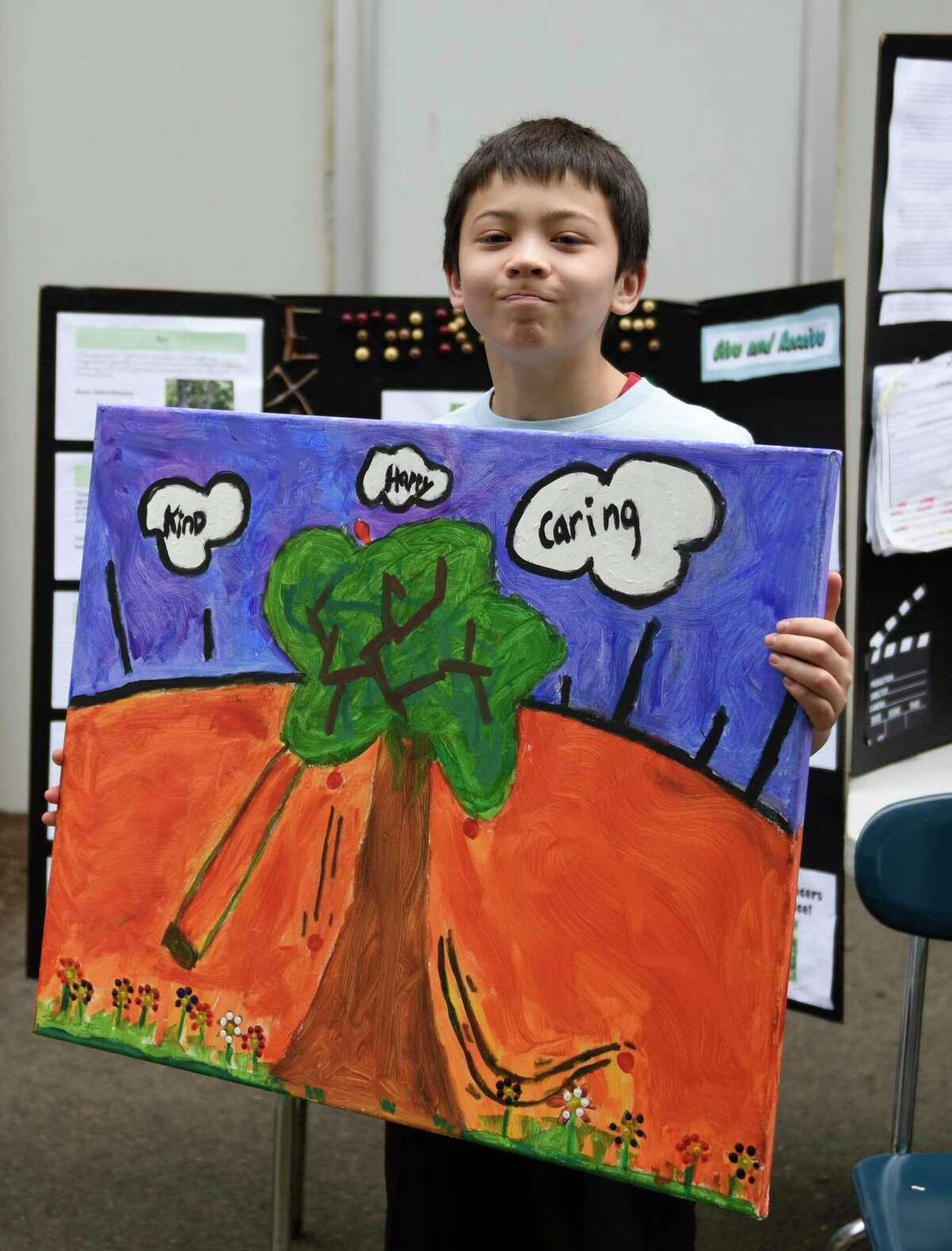 Fifth-grader Isaac Farr presents Greenwich Police officers with a painting about his Art Expression research project at the International School in Dundee, Riverside, Greenwich, Connecticut, Tuesday, June 21, 2022. Farr's research project was on Art and Gratitude and created a picture of the Greenwich Police Department to express his gratitude through art.