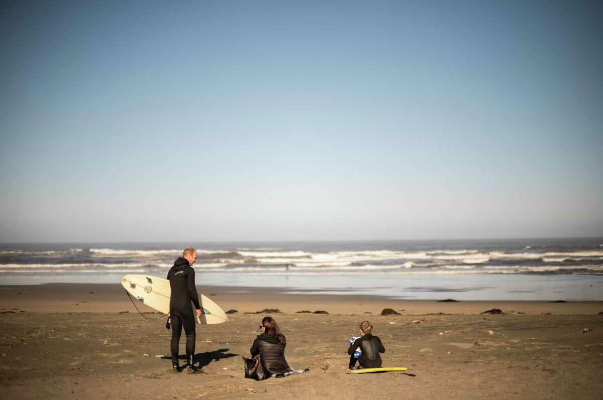 The Oakes family, Matt, Kristy and Adam, of Petaluma, try to warm up after a short surfing session at Salmon Creek. Ocean temperatures along the Bay Area coast dipped to 47.8 degrees at a Bodega Bay buoy on June 21, the coldest it’s been that day in over a decade.
