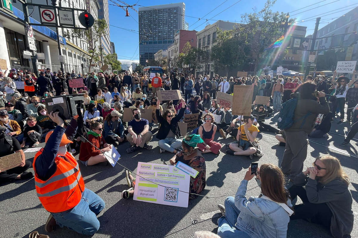 Protesters prepare a sit-in at the intersection of 8th and Market Street, for 49 minutes - the number of years Row vs. Wade was in existence - during widespread protests in downtown San Francisco, on Friday, June 24, in response to the Supreme Court's decision to overturn the longstanding precedent legalizing abortion in America. 