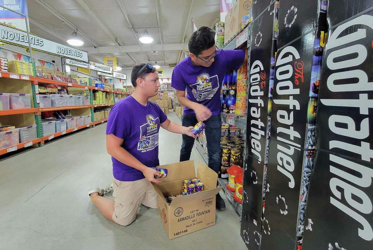 Joshua Sanchez, 12, bassoon player and Tristen Flores, 12, clarinetist work together stocking the shelves of the Top Dog Fireworks Warehouse in Crosby. They are helping raise money for the Crosby band program.