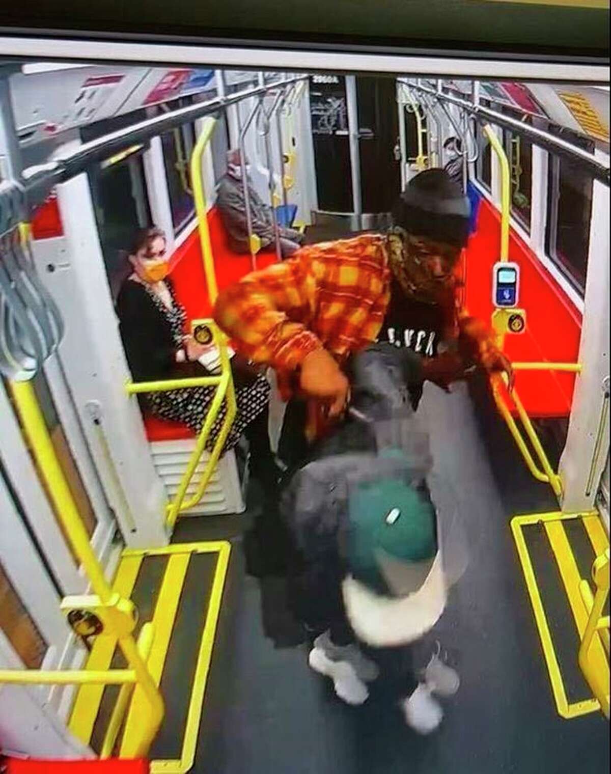 Nesta Bowen (in orange) attacks a man who appears to be Javon Green with what looks like a knife on a Muni train in a still from surveillance video.