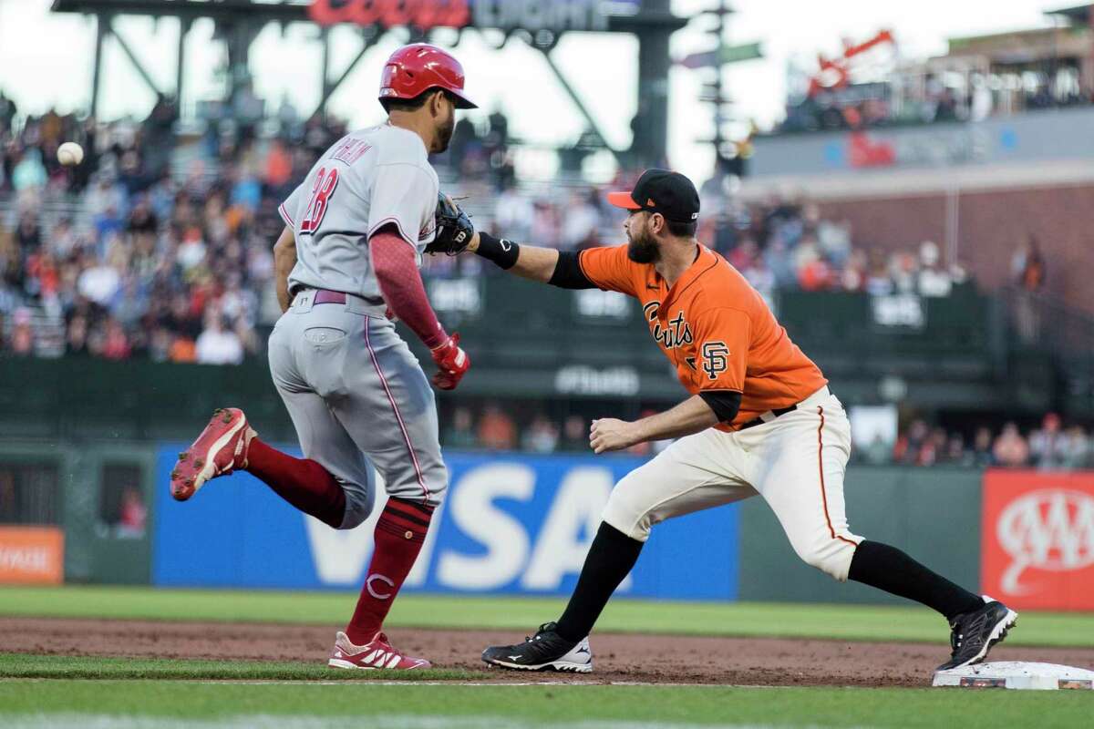 San Francisco Giants first baseman Brandon Belt, right, forces out Cincinnati Reds' Tommy Pham (28) in the second part of a double play during the third inning of a baseball game in San Francisco, Friday, June 24, 2022. (AP Photo/John Hefti)