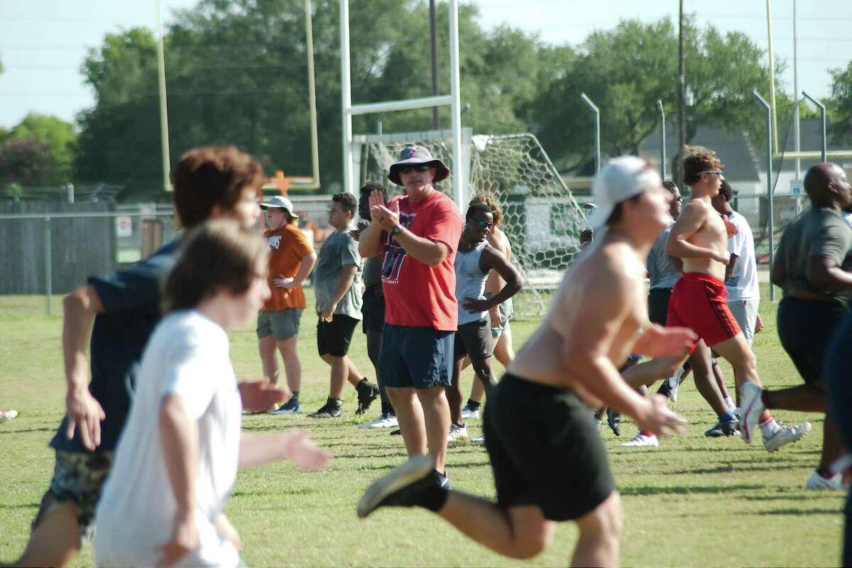 Dawson head football coach Mike Allison reacts as players participate in a conditioning drill at the Dawson summer strength and conditioning camp.