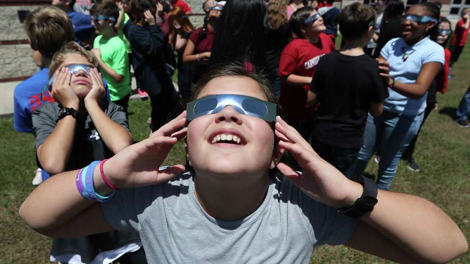 Rogers Middle School 6th grader Evangeline Curless (foreground) and her classmates used eclipse glasses, Monday, Aug. 21, 2017, in Pearland. Rogers' Principal Lakesha Vaugh said that between Pearland ISD and the teachers they were able to purchase about 820 eclipse glasses allowing the entire student body to witness the historic event.