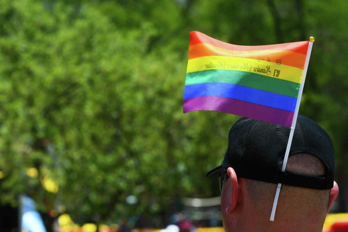 A festival attendee adds a Pride flag to his hat during the San Antonio Pride festival at Crockett Park on Saturday, Jun. 25, 2022.