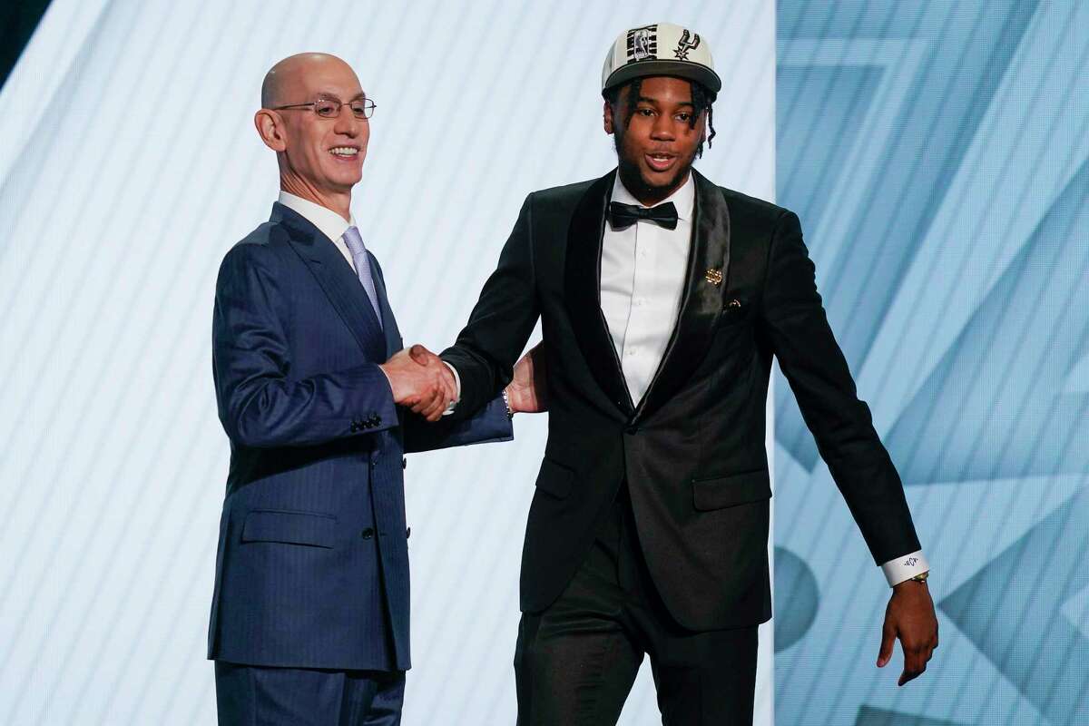 Blake Wesley, right, shakes hands with NBA Commissioner Adam Silver after being selected 25th overall by the San Antonio Spurs in the NBA basketball draft, Thursday, June 23, 2022, in New York. (AP Photo/John Minchillo)