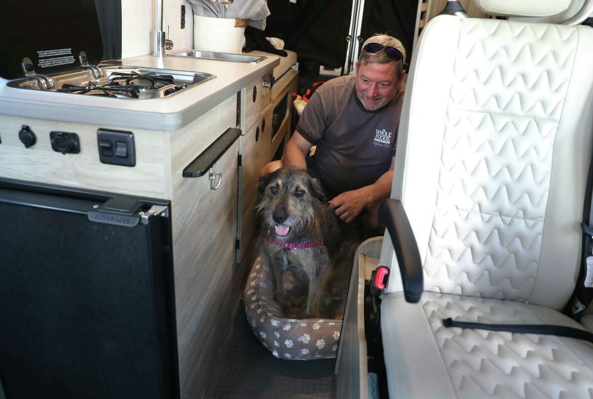 Simple Camper renter Keith Fletcher settles Lola into her bed before they leave for a getaway in a camper van.