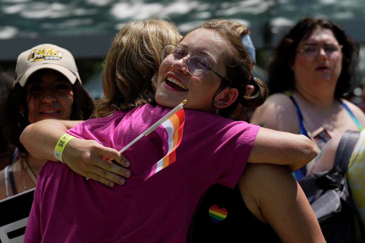 Logan McLean embraces a friend while attending Pride Houston, Saturday, June 25, 2022, in Houston. “We need this,” said McLean referring to the U.S. Supreme Court overturning Roe v. Wade the previous day on Friday.