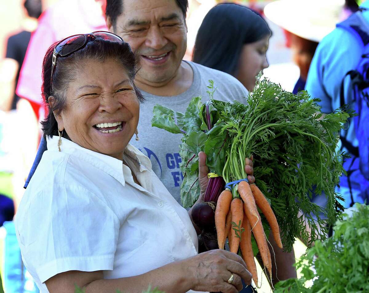 Maria and Julio Romero shop for fresh vegatables at the Danbury Farmers Market on the CityCenter Green, Saturday, June 25, 2022.