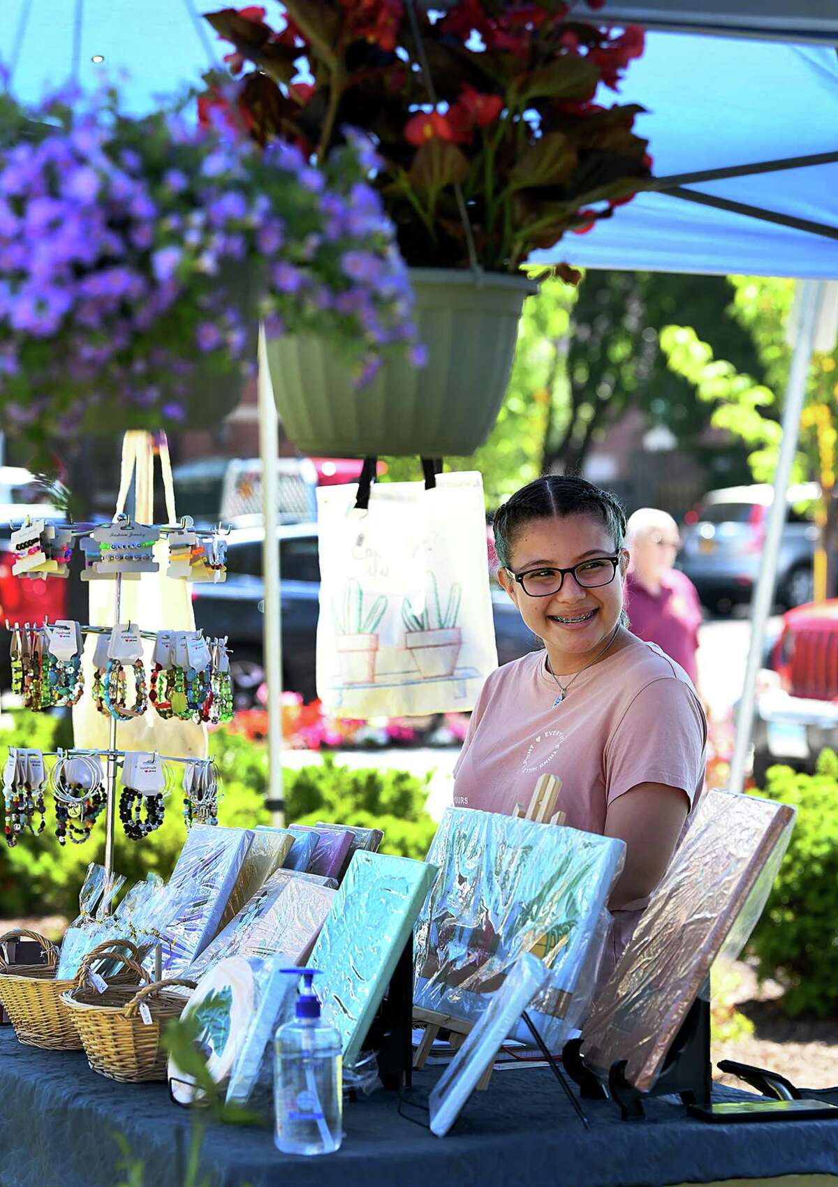 Dayana Flores of FG Arts & Crafts mans her booth at the Danbury Farmers Market on the CityCenter Green, Saturday, June 25, 2022.