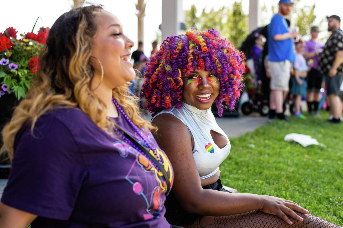 Saginaw resident Cyan Goodwin (right) sits in the shade with Saginaw resident Kaylynn Martin at the Great Lakes Bay Pride Festival on June 25, 2022 at Wenonah Park in Bay City.