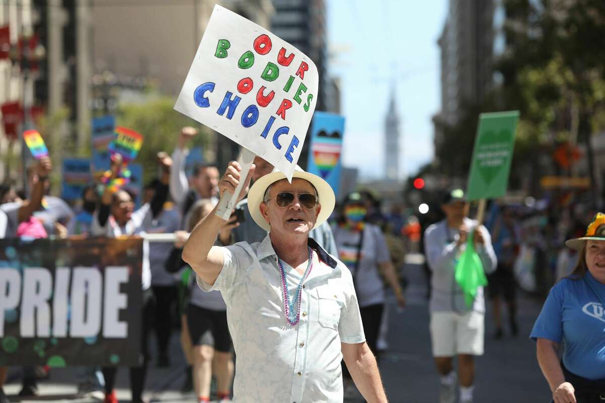 Attendees at San Francisco Pride march down the parade route on June 26, 2022.