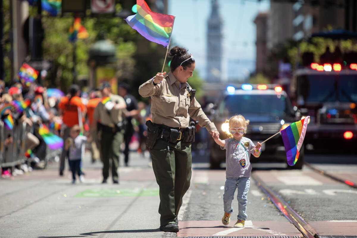Sheriff Claudia Gomez and her daughter Olivia wave rainbow flags during the San Francisco Pride parade in San Francisco, Calif.  on June 26, 2022.