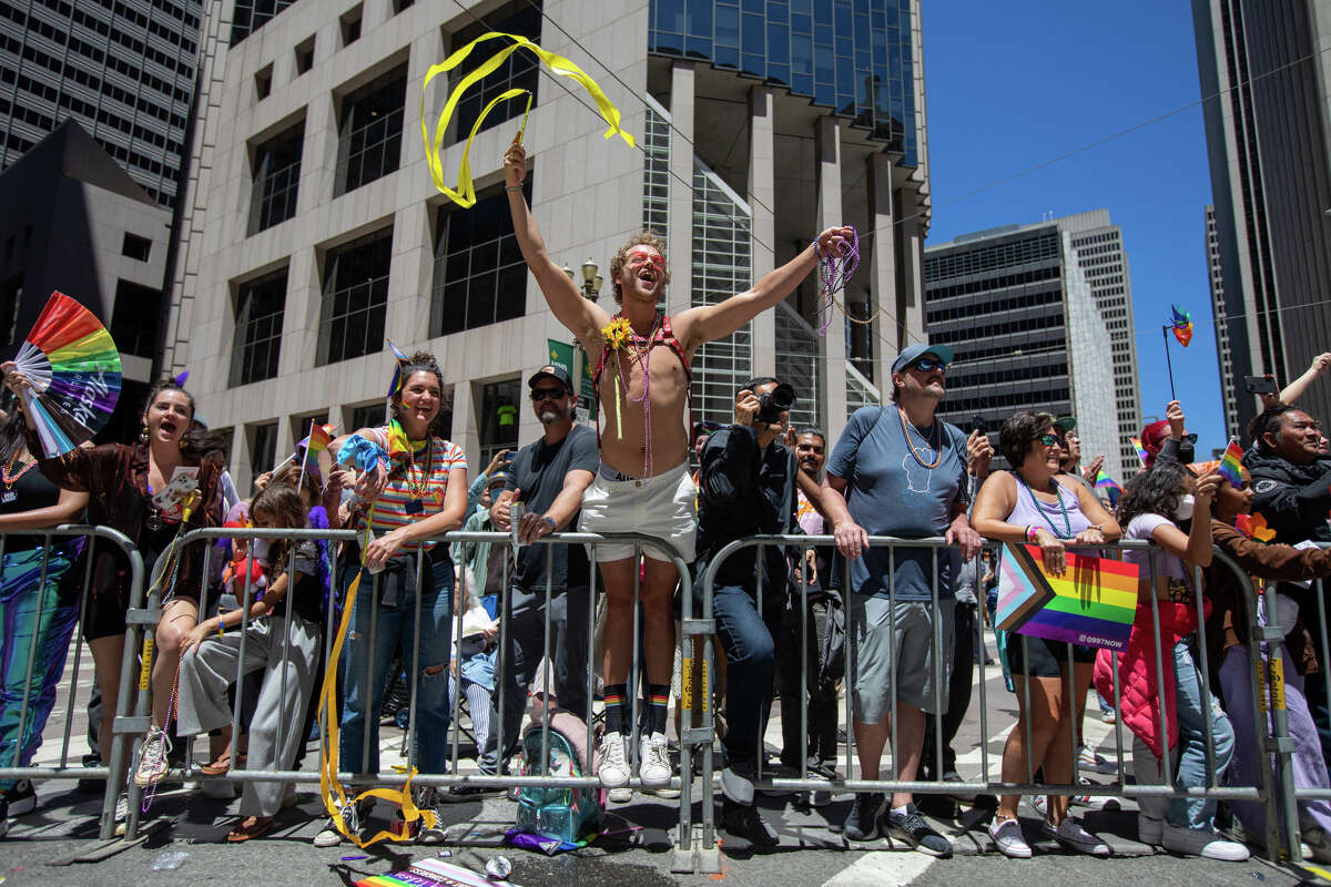 Tyler Weisman from Denver, CO (center) cheers participants during the the San Francisco Pride parade in San Francisco, Calif.  on June 26, 2022.