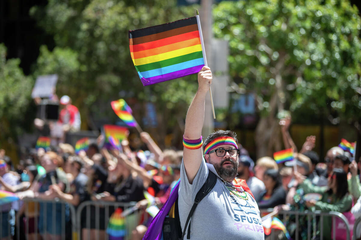 Sam Bass holds up a rainbow flag during the San Francisco Pride parade in San Francisco, Calif. on June 26, 2022.