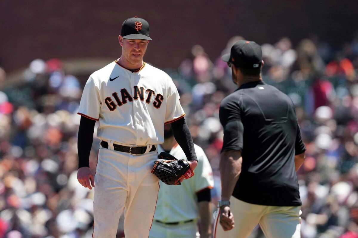 San Francisco Giants starting pitcher Anthony DeSclafani, left, stands on the mound as manager Gabe Kapler, right, approaches to make a pitching change during the third inning of a baseball game against the Cincinnati Reds Sunday, June 26, 2022, in San Francisco, Calif. (AP Photo/Darren Yamashita)