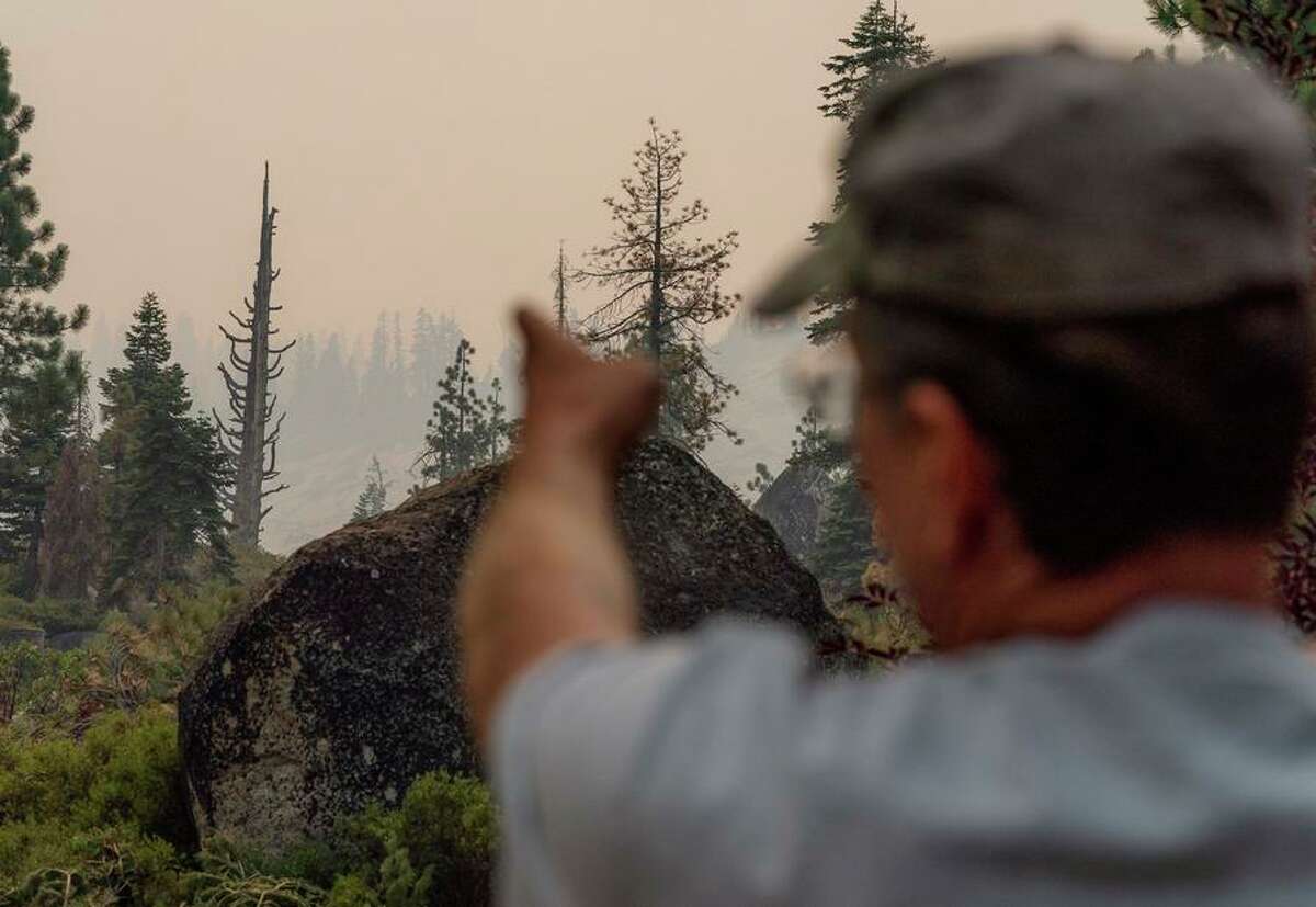 Retired firefighter Scott Swift points to where the Caldor Fire came down near his home in South Lake Tahoe in 2021.