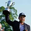 Xander Schauffele holds the trophy after winning the Travelers Championship at TPC River Highlands Sunday in Cromwell.