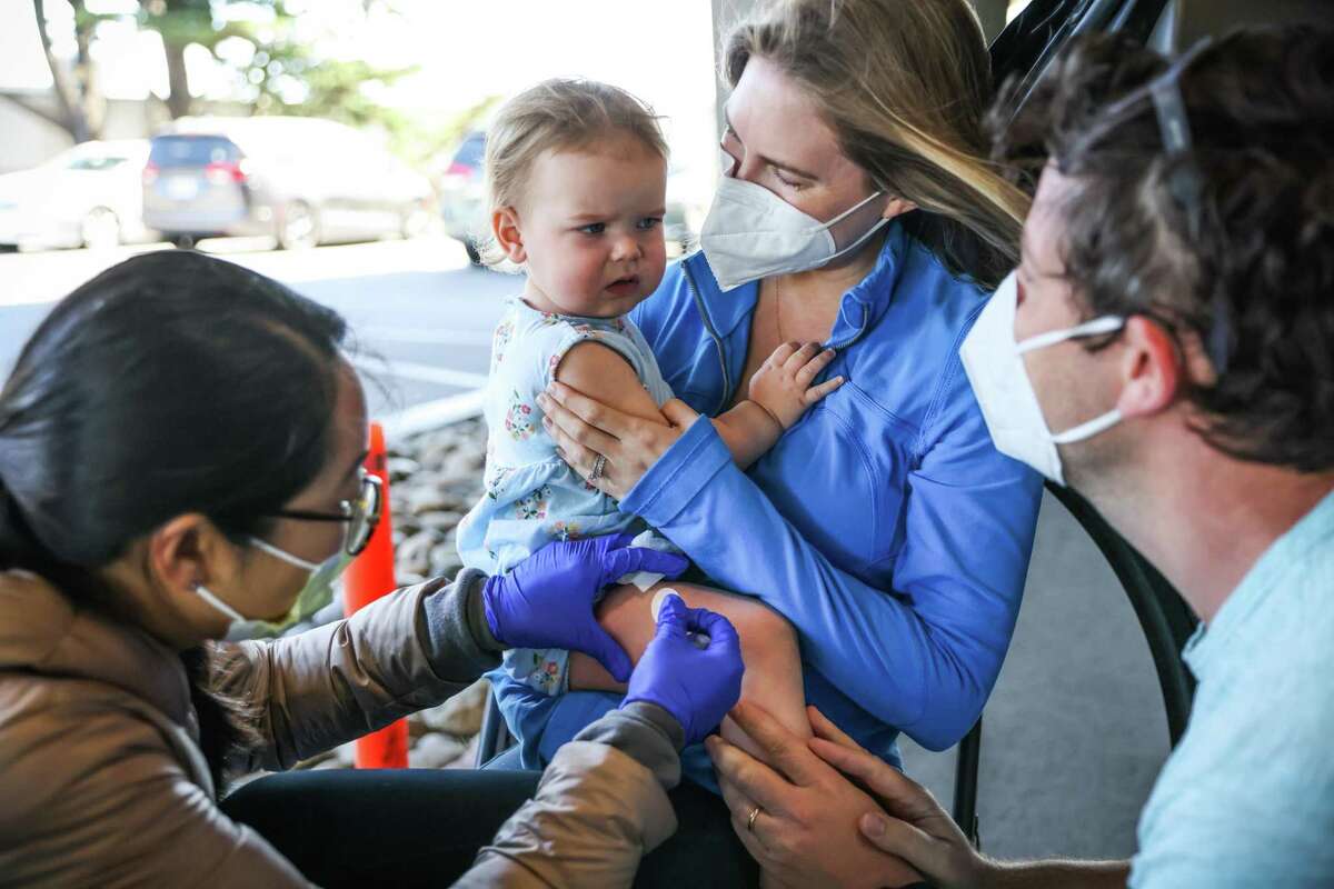 Elizabeth Goffinet (center) embraces daughter Wesley Goffinett, 16 months, after the child received a COVID-19 vaccine at UCSF Laurel Heights. Many parents are eagerly getting their youngest offspring vaccinated now that children under 5 are eligible for the shots.