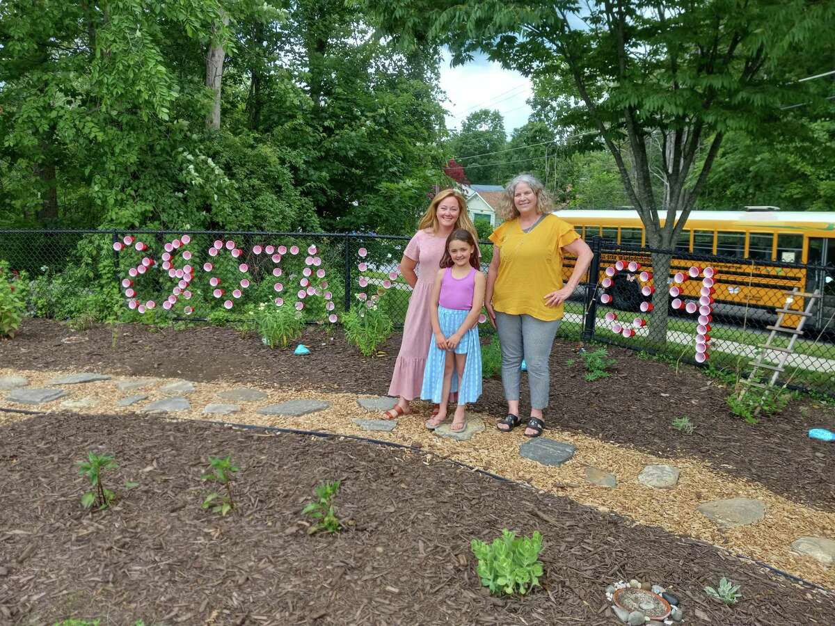 Karen Mangine, right, and Erin French, kindergarten teachers at the Torringford School have created a pollinator garden and hope to continue the project to include an outdoor classroom space and a trail. Also pictured is French’s daughter, Elle.