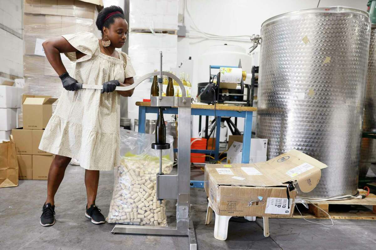 Aaliyah Nitoto seals wine with a cork at Free Range Flower Winery, Saturday, June 25, 2022, in Livermore, Calif.  Nitoto is a winemaker who makes small batches from locally grown and cultivated flowers.