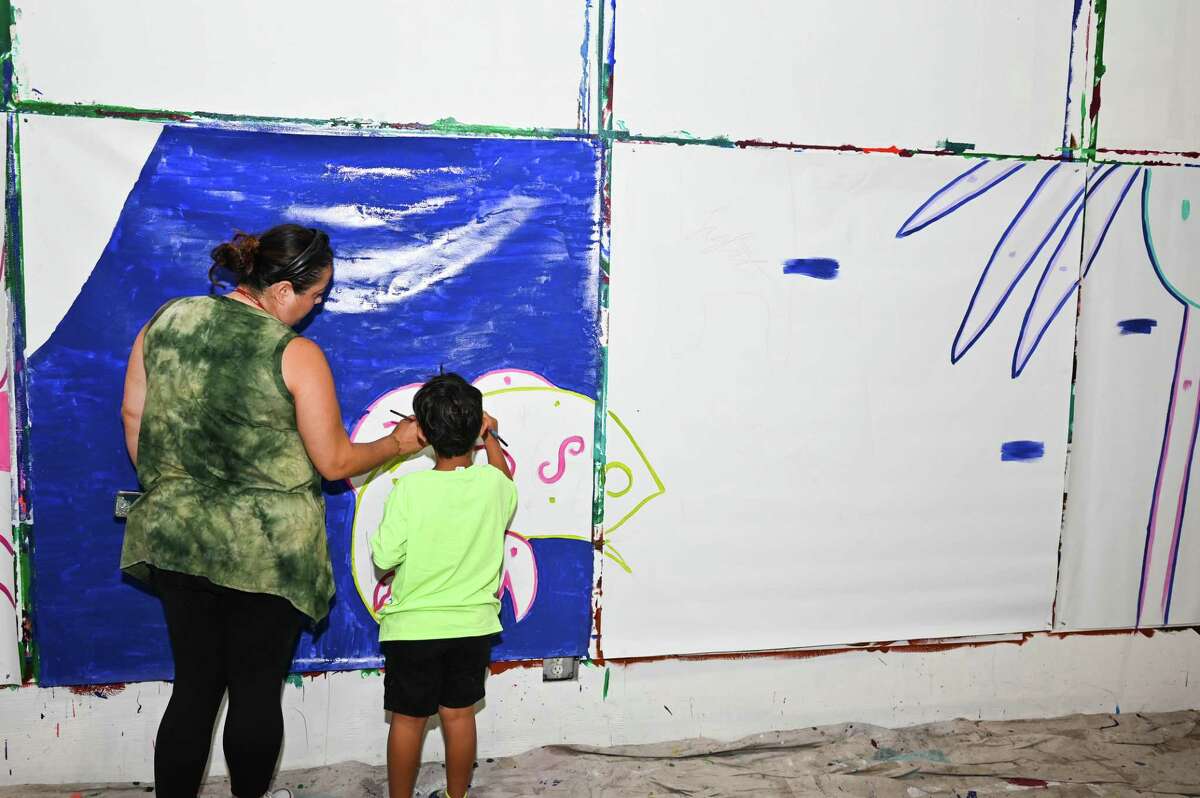 Jenny Cisneros paints with Gavin Luna, 5, during the community paint day at the San Antonio Cultural Art’s Center. Residents are invited to contribute to the development of a mural that will be installed at Market Square’s Farmer’s Market in the fall.