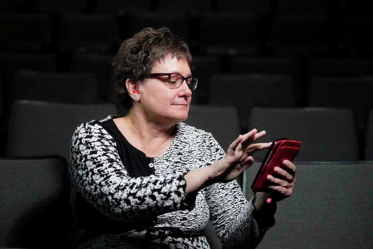 Chelle Wyatt uses her cell phone with the Otter app Friday, April 15, 2022, in Salt Lake City. People with hearing loss have adopted technology to navigate the world, especially as hearing aids are expensive and inaccessible to many. (AP Photo/Rick Bowmer)