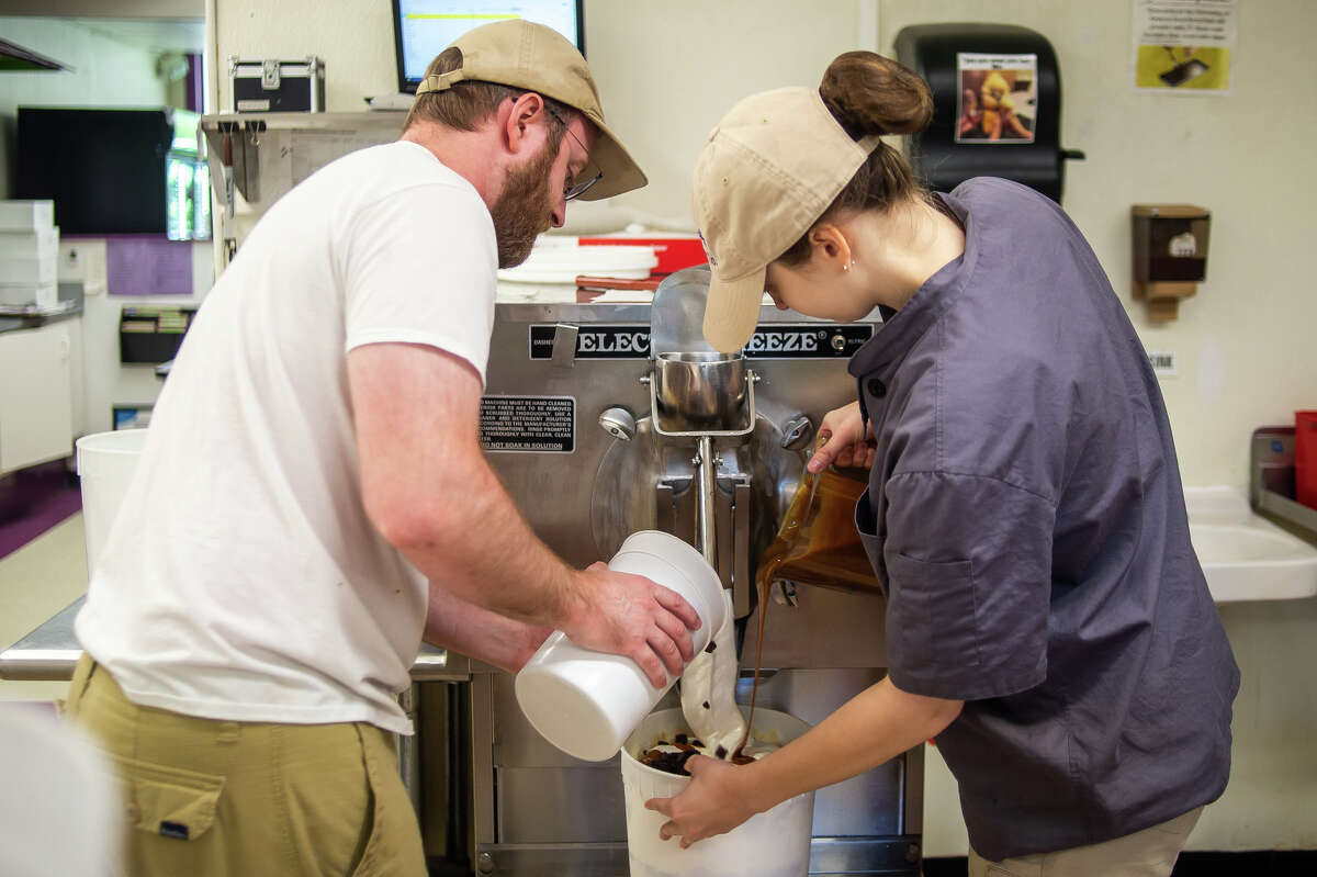 Great Lakes Ice Cream Company Operations Manager Andrew Pirie (left) and ice cream maker Abby Wisniewski mix ice cream at Great Lakes Ice Cream Company on June 23, 2022 in Midland.
